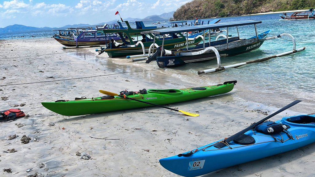 Kayaks drawn up beside outrigger jukungs